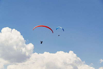 Low angle view of person paragliding against sky