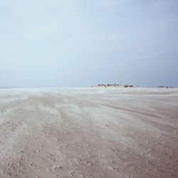 Scenic view of beach against sky on sunny day