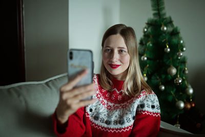 Portrait of smiling young woman using smart phone