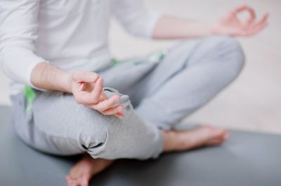 Low section of man doing yoga in studio