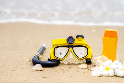 Close-up of yellow toys on the beach