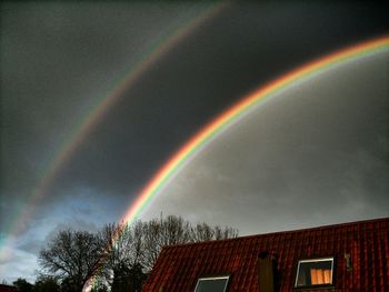 Low angle view of rainbow over built structure