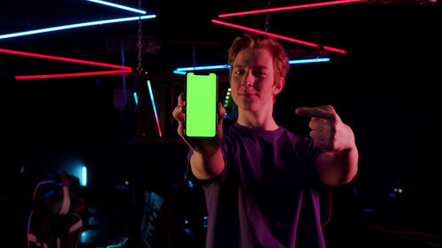 Young man using smart phone at music concert