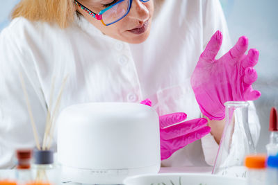 Aroma diffuser in a lab, olfactory science technician smelling the fragrance.