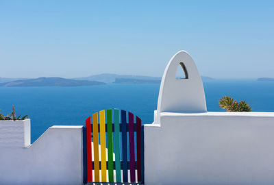 Facade of brick fence or small white wall with a rainbow gate to