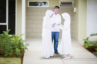 Man and woman standing by building