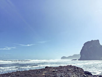 View of calm beach against blue sky