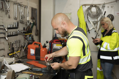 Male and female colleagues working in workshop