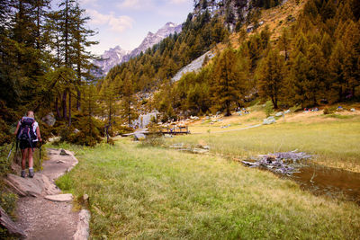 People on grassy field against mountains