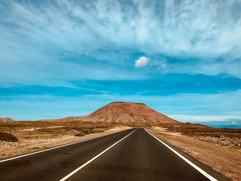 Street to corralejo in the northern part of fuerteventura, red mountain,  fuerteventura island