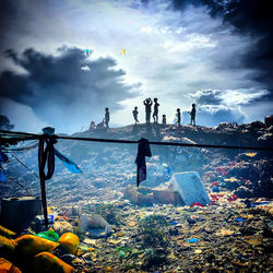 People on shore against sky