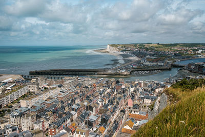 High angle view of townscape by sea against sky