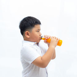 Boy holding ice cream against white background