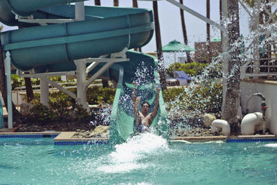 Man sliding on slide at water park