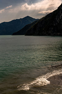 Scenic view of sea and mountains against sky