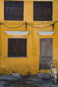 Bicycle parked outside yellow building