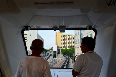 Rear view of men sitting in metro train