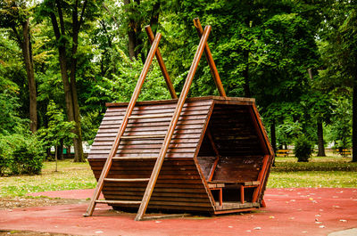 Wooden seat against trees in park