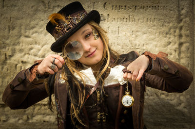 Portrait of young woman looking through magnifying glass