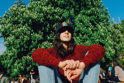 Young woman wearing hat against trees