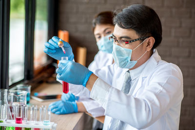 Man and woman examining test tube in laboratory
