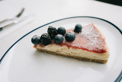 Slice of cheesecake topped with blueberries