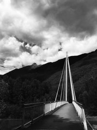 Bridge over river against cloudy sky