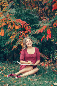 Portrait of a smiling young woman sitting outdoors