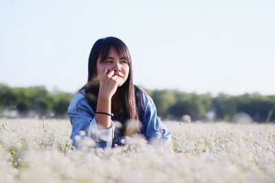 Girl looking away by blooming flowers