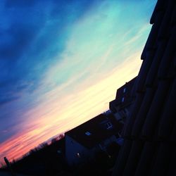 Buildings against cloudy sky at sunset