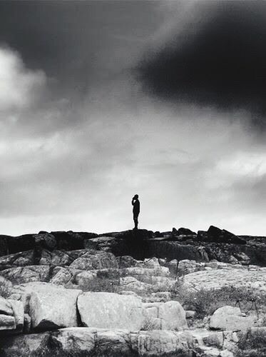 sky, rock - object, lifestyles, full length, standing, leisure activity, men, cloud - sky, rock formation, rear view, rock, silhouette, person, nature, tranquility, low angle view, stone wall, tranquil scene
