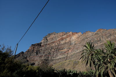 Low angle view of rock formation against clear blue sky