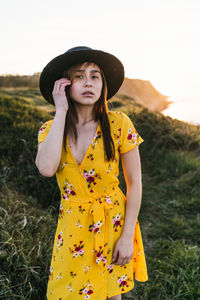 Young woman wearing hat standing on field