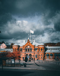 Buildings in city against cloudy sky