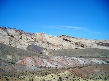 Scenic view of arid landscape against clear blue sky