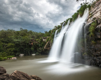 Scenic view of waterfall against sky