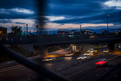 Blurred motion of cars on illuminated city against sky at night