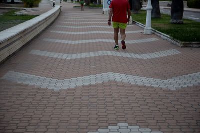 Low section of woman walking on footpath
