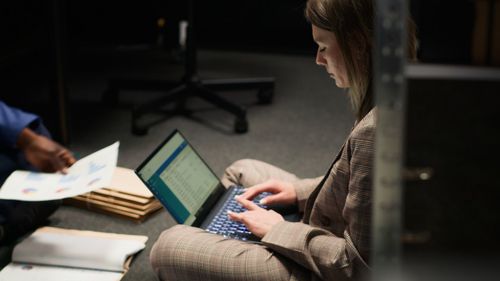 Midsection of man using digital tablet while sitting on table