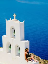 People in front of sea against blue sky