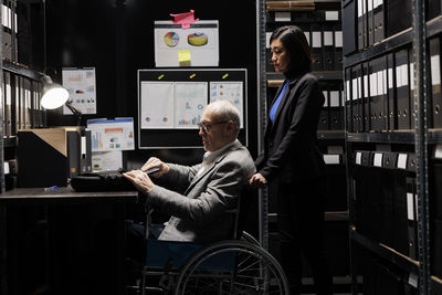 Rear view of man using mobile phone in office