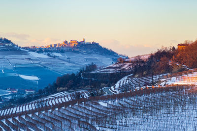 High angle view of snowcapped field against sky during sunset