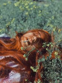 Woman holding cigarette in mouth by plants