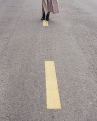 Low section of person walking on road