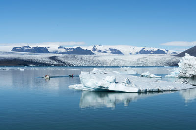 Icebergs floating in sea against sky during winter