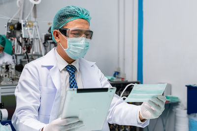 Doctor wearing mask and digital tablet