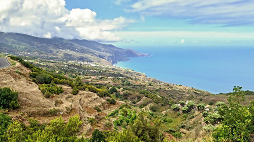 Scenic view of sea and mountains against sky