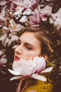 Young woman amidst pink flowers during springtime