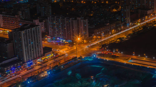 High angle view of illuminated city street and buildings at night