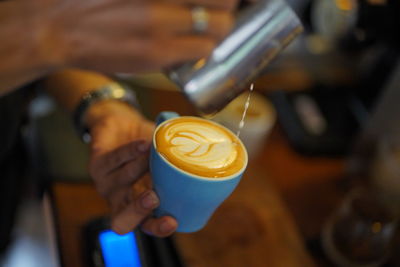 Woman holding coffee cup at cafe